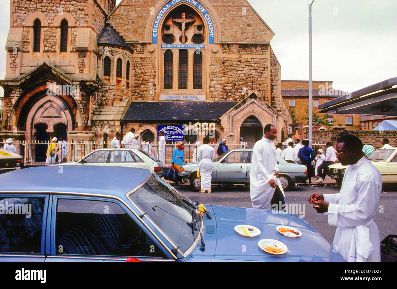 The Celestial Church Of Christ, Elephant & Castle, London UK. A church member snacks on food, using a car as a makeshift table. Stock Photo