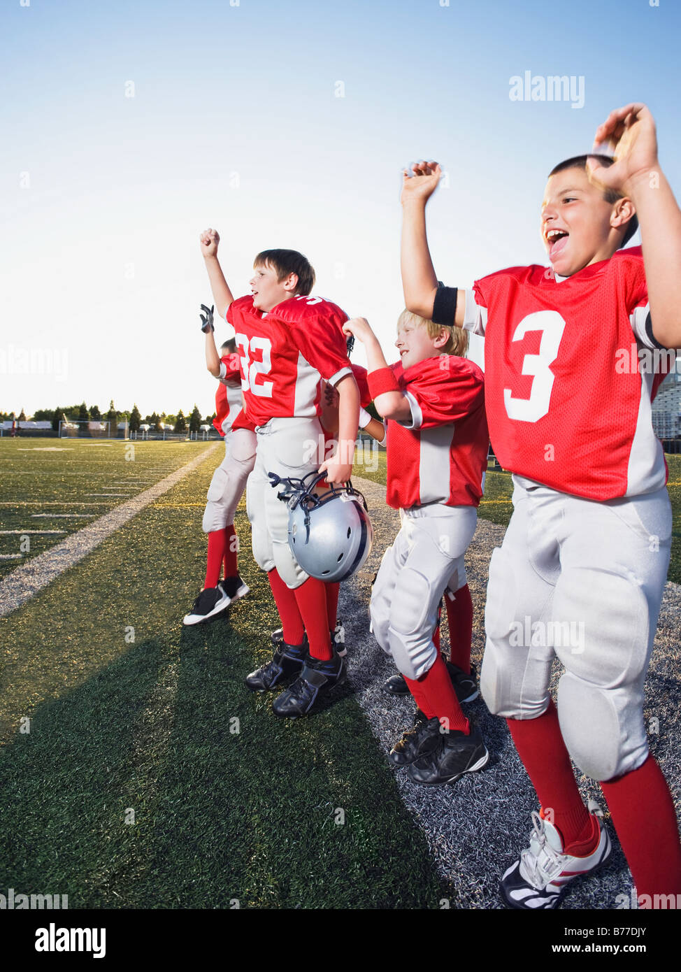 Football players cheering on sideline Stock Photo