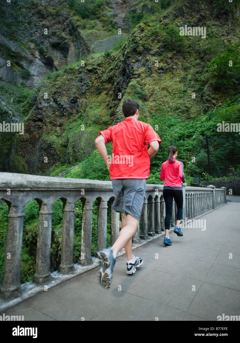 Couple running across bridge Stock Photo Alamy