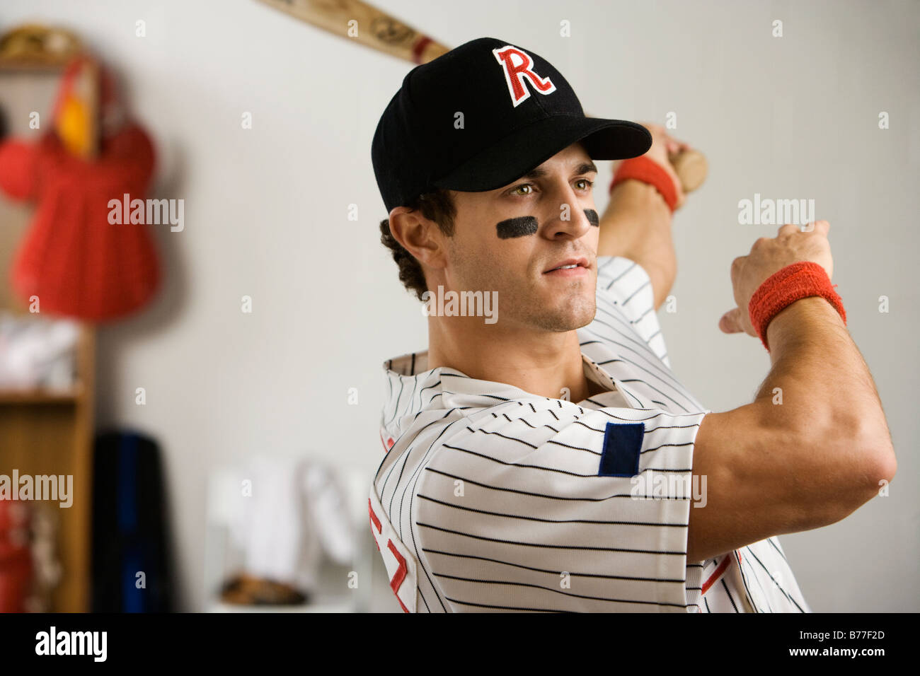 Baseball player practicing swing locker room Stock Photo