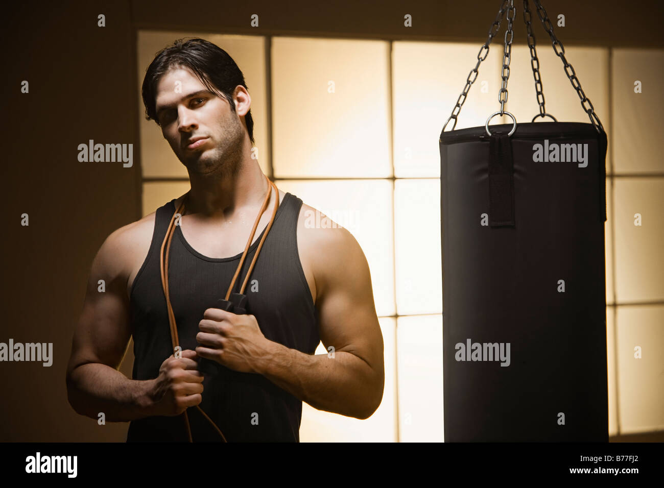 Man jump rope posing by punching bag Stock Photo Alamy