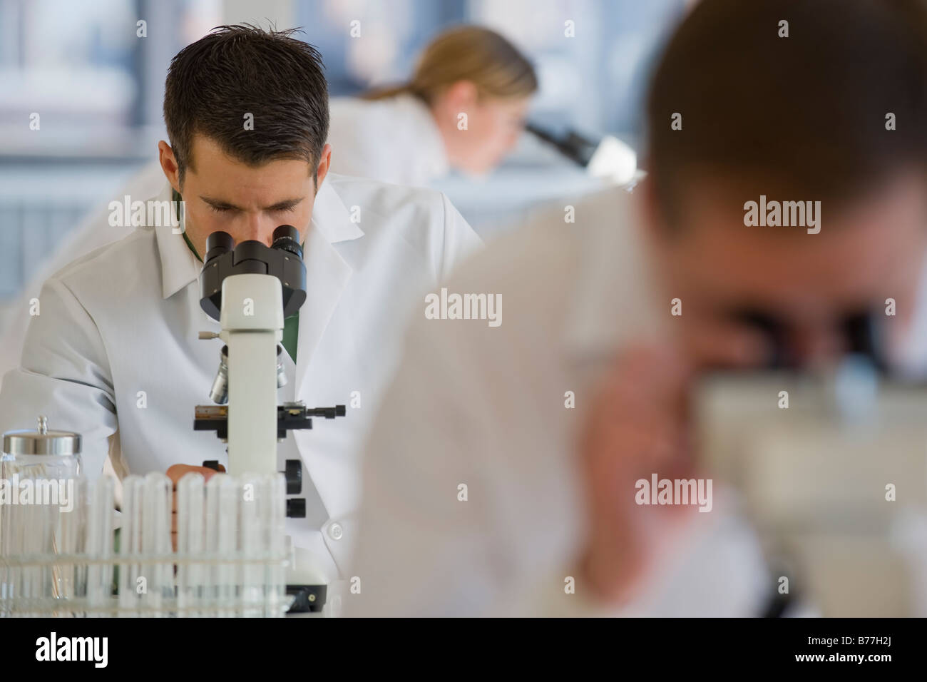 Scientists using microscopes pharmaceutical laboratory Stock Photo