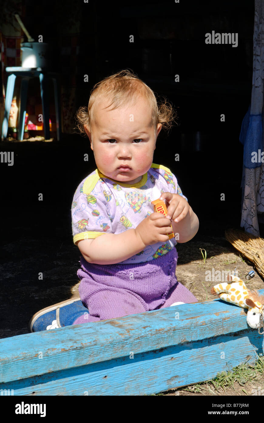 Baby, toddler sitting in the entrance of a yurt, Ger, Altai, Russia, Siberia, Asia Stock Photo