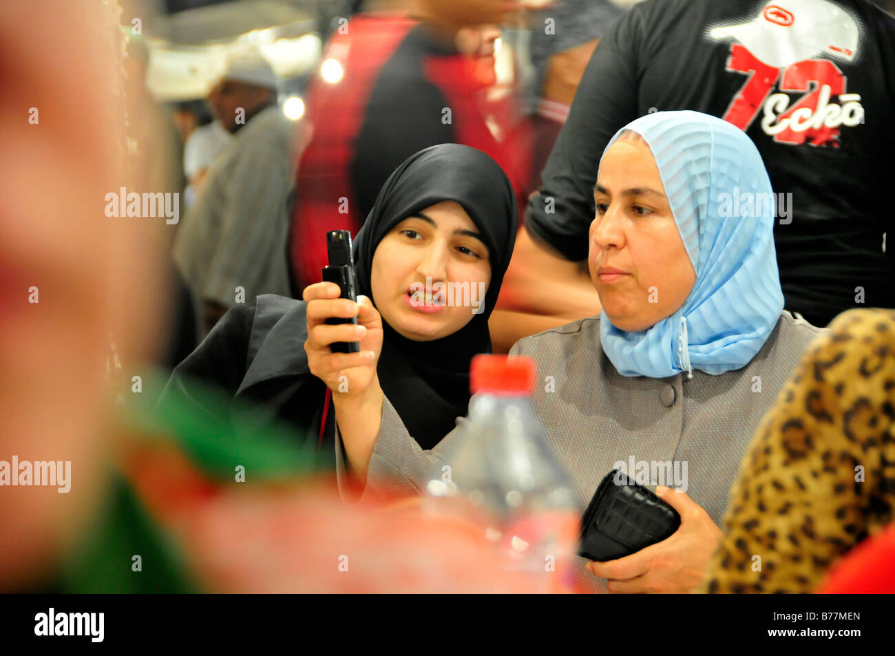 Two veiled women with a camera phone in a restaurant in the Place Djemma el-Fna, Square of the hanged, imposter square, Marrake Stock Photo