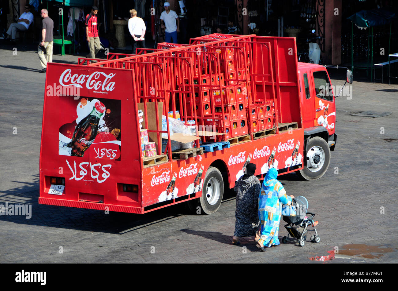 Veiled women in front of a Coca-Cola lorry in the Place Djemma el-Fna, Square of the hanged, imposter square, Marrakech, Morocc Stock Photo