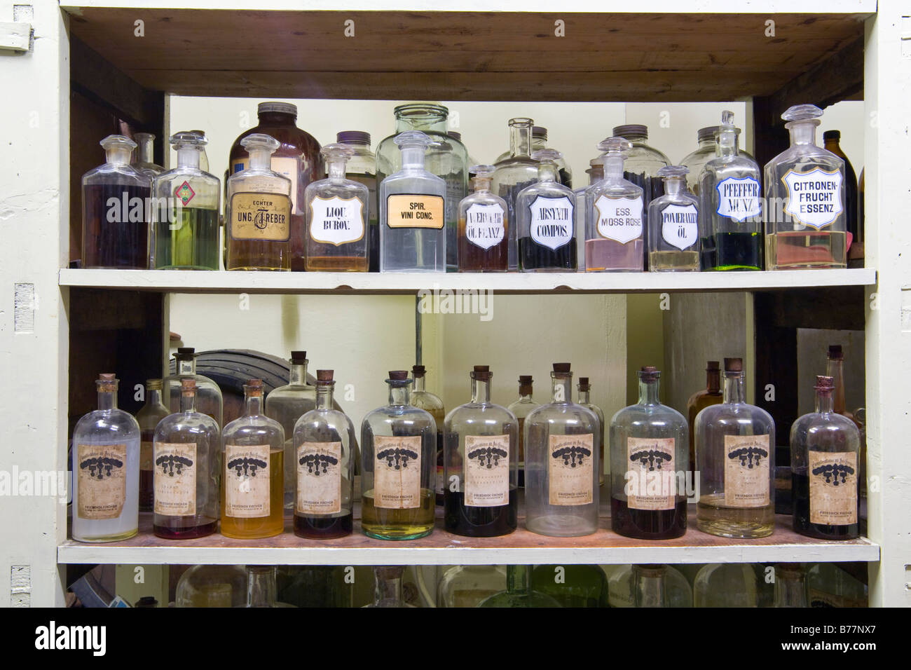 Old glass bottles filled with essences in an old chemical storage Stock Photo