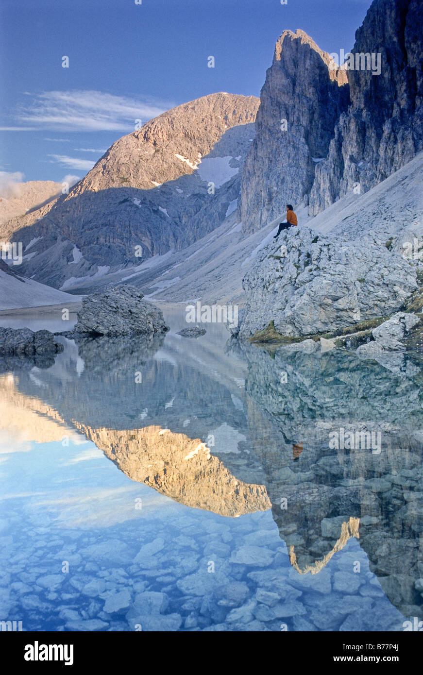 Hiker sitting by the Lago di Antermoia mountain lake, Rosengarten