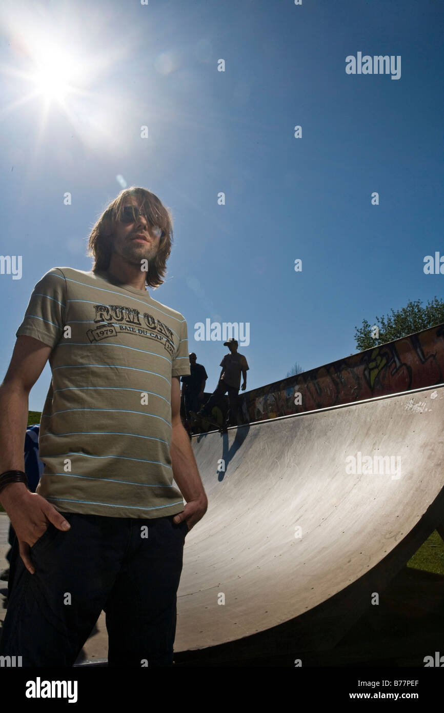Young man standing in front a skateboard ramp Stock Photo
