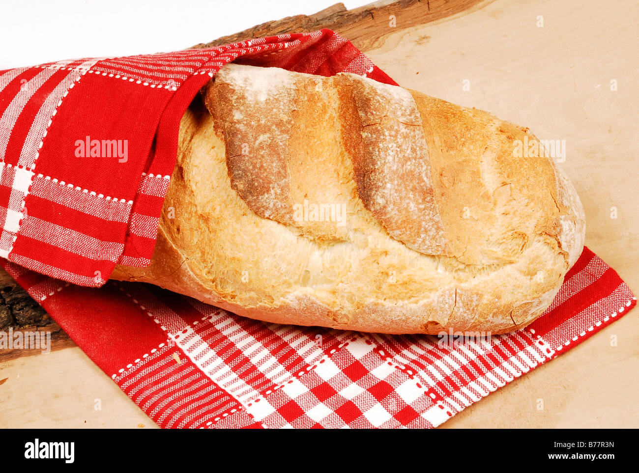 Loaf of bread wrapped in a tea towel Stock Photo