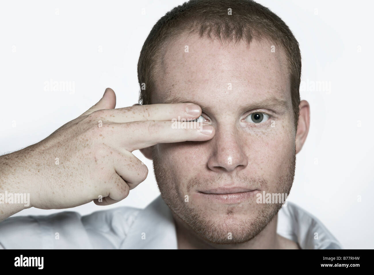 Portrait of a young man, gesture, covering one eye with two fingers Stock Photo
