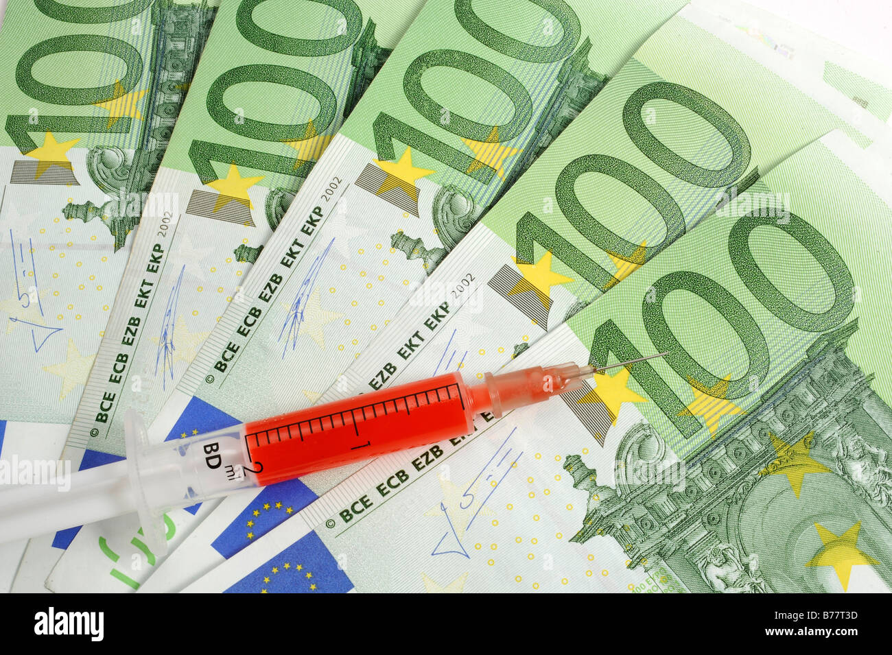 Syringe over 100 Euro banknotes, symbolic for a cash injection Stock Photo