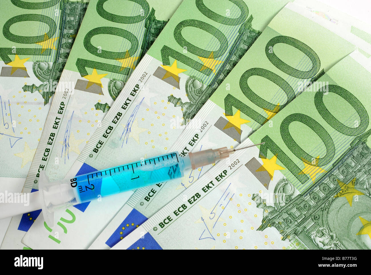 Syringe over 100 Euro banknotes, symbolic for a cash injection Stock Photo