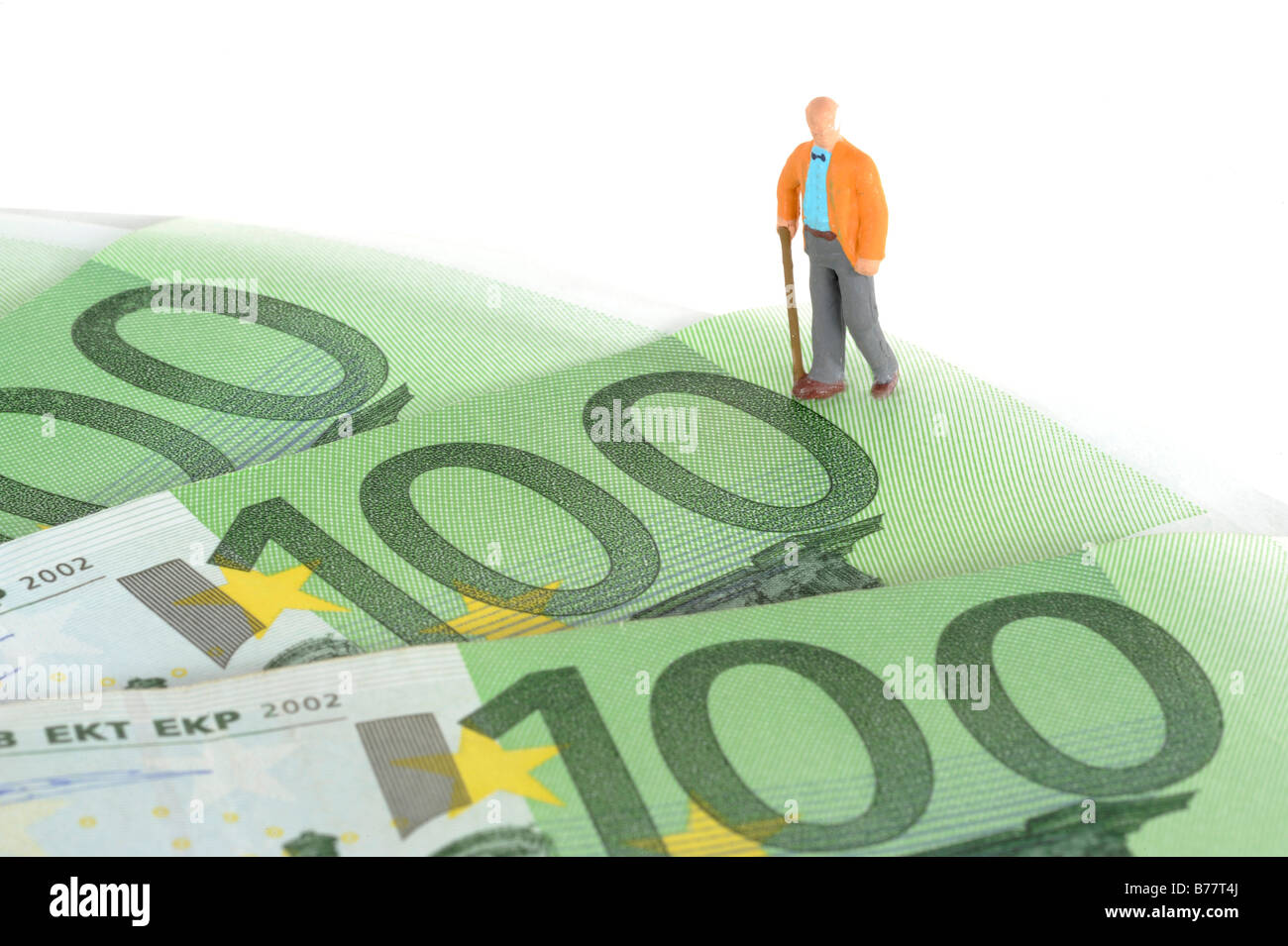 Figure of an elderly man walking over Euro banknotes, symbolic image for pension plan, retirement Stock Photo