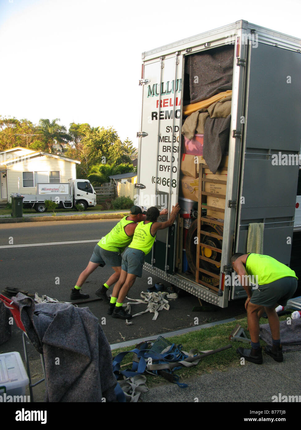 Removalists close the door of a house removing truck Stock Photo