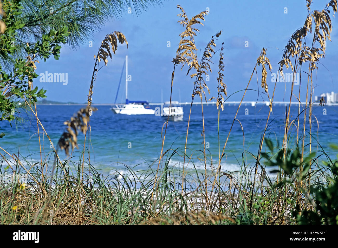 Sea oats and anchored boats beach Sanibel Island Florida Stock Photo
