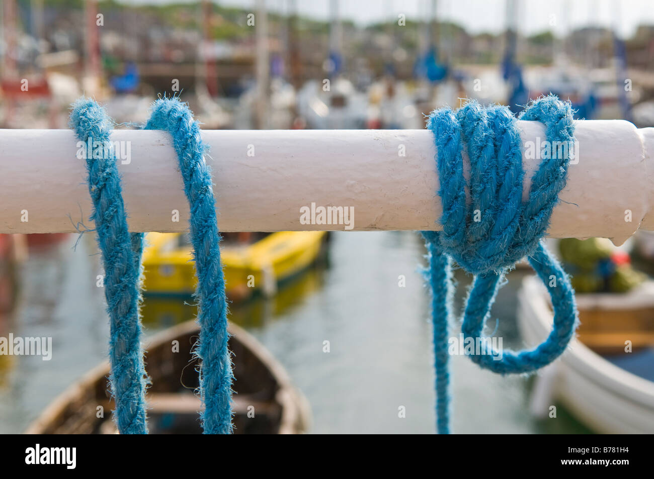 Mooring rope tied to the railing at the harbour. Stock Photo