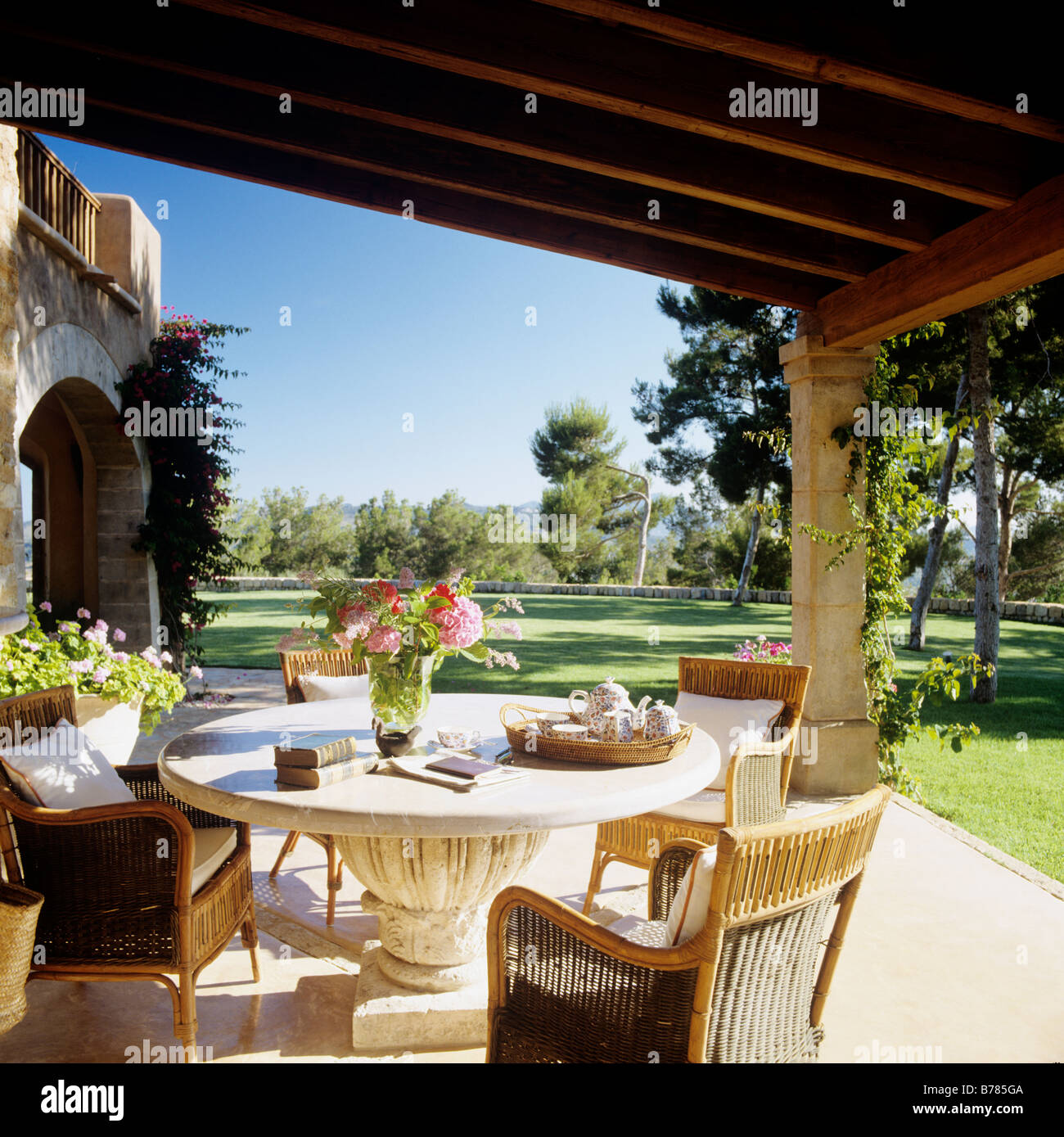 Stone table and wicker chairs on veranda / porch of Mallorcan finca restoration Stock Photo