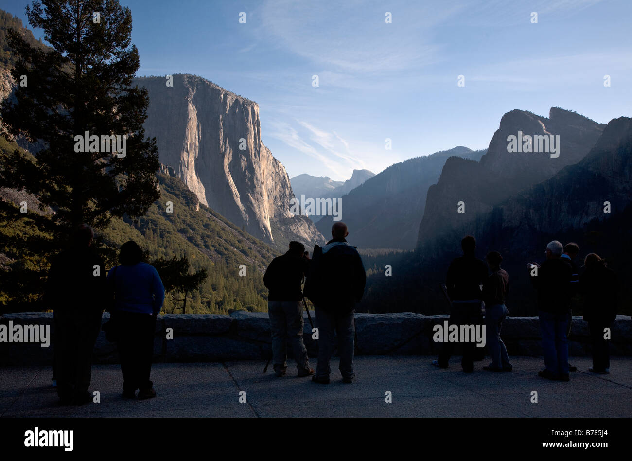 Tourists enjoy the view of YOSEMITE VALLEY showing EL CAPITAN and HALF DOME YOSEMITE NATIONAL PARK CALIFORNIA Stock Photo