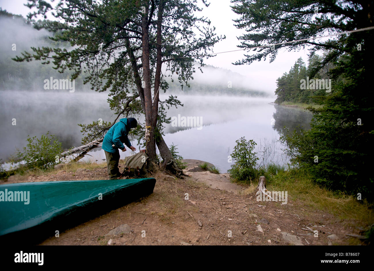Taking down the food pack that hangs from a tree at base camp in Boundary Waters Canoe Area in