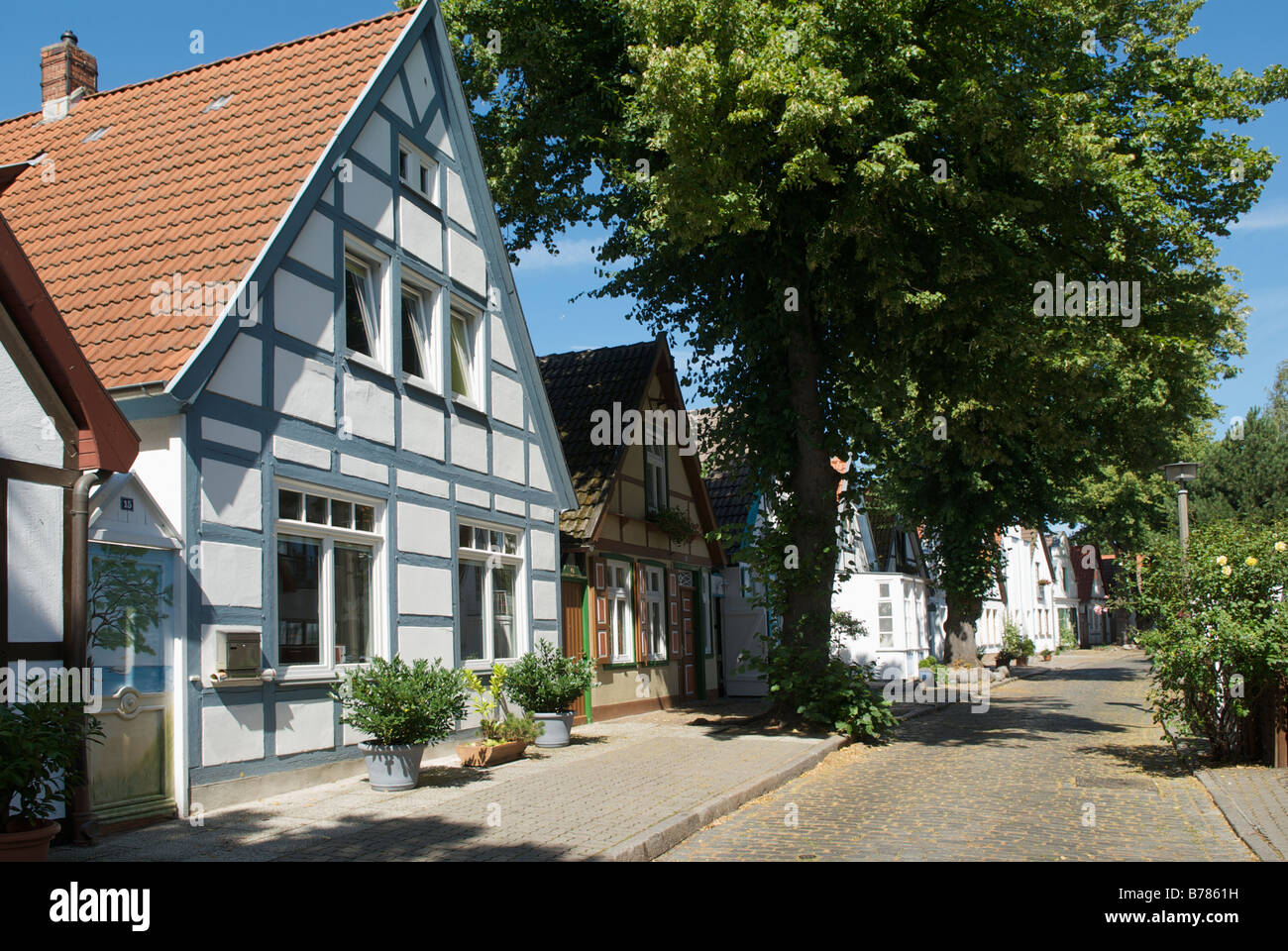 Pretty row of houses and Bed and Breakfast guesthouses in quiet cobble stoned Alexandrinenstrasse Warnemunde Germany Stock Photo