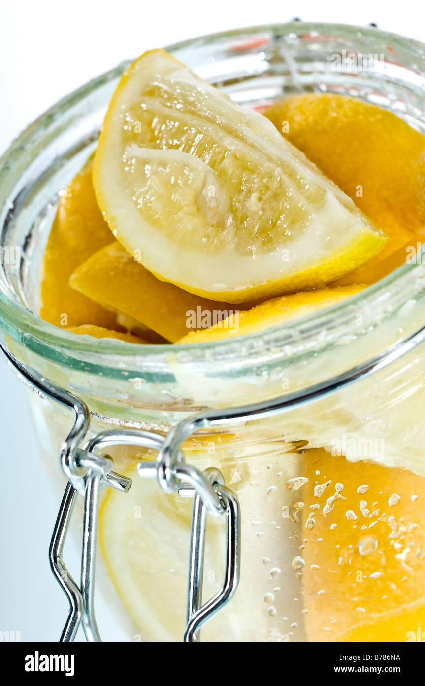 Parfait jars of preserved lemons. Quarters of lemons are covered in salt then topped up with