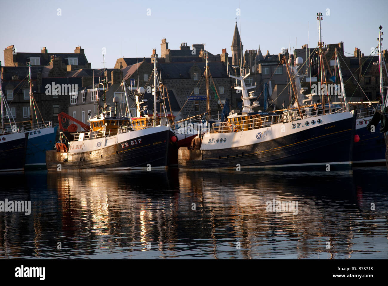 Moored herring Fishing boats; Ships with abstract bow reflections at Fraserburgh Harbour, north-facing coast of Aberdeenshire, Scotland, uk Stock Photo