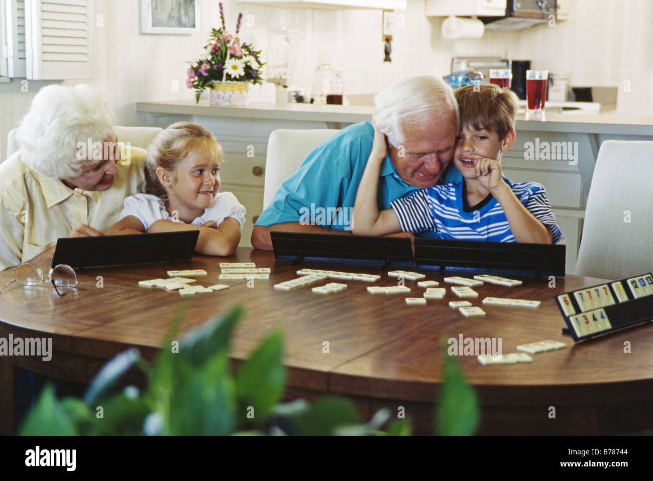 Grandparents and grandkids together, playing board games, Miami Stock Photo