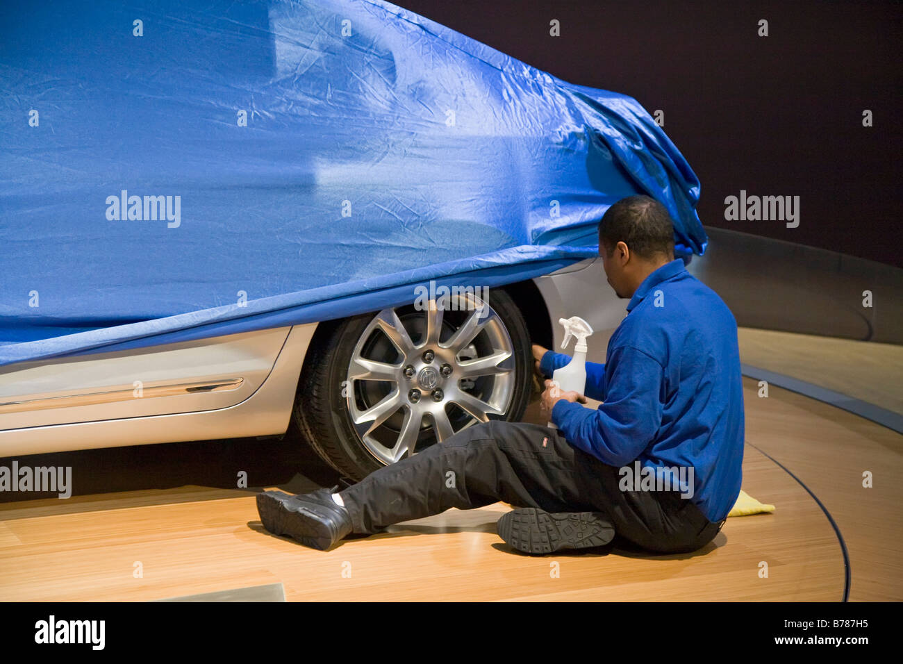 Worker Polishes Car at Detroit Auto Show Stock Photo