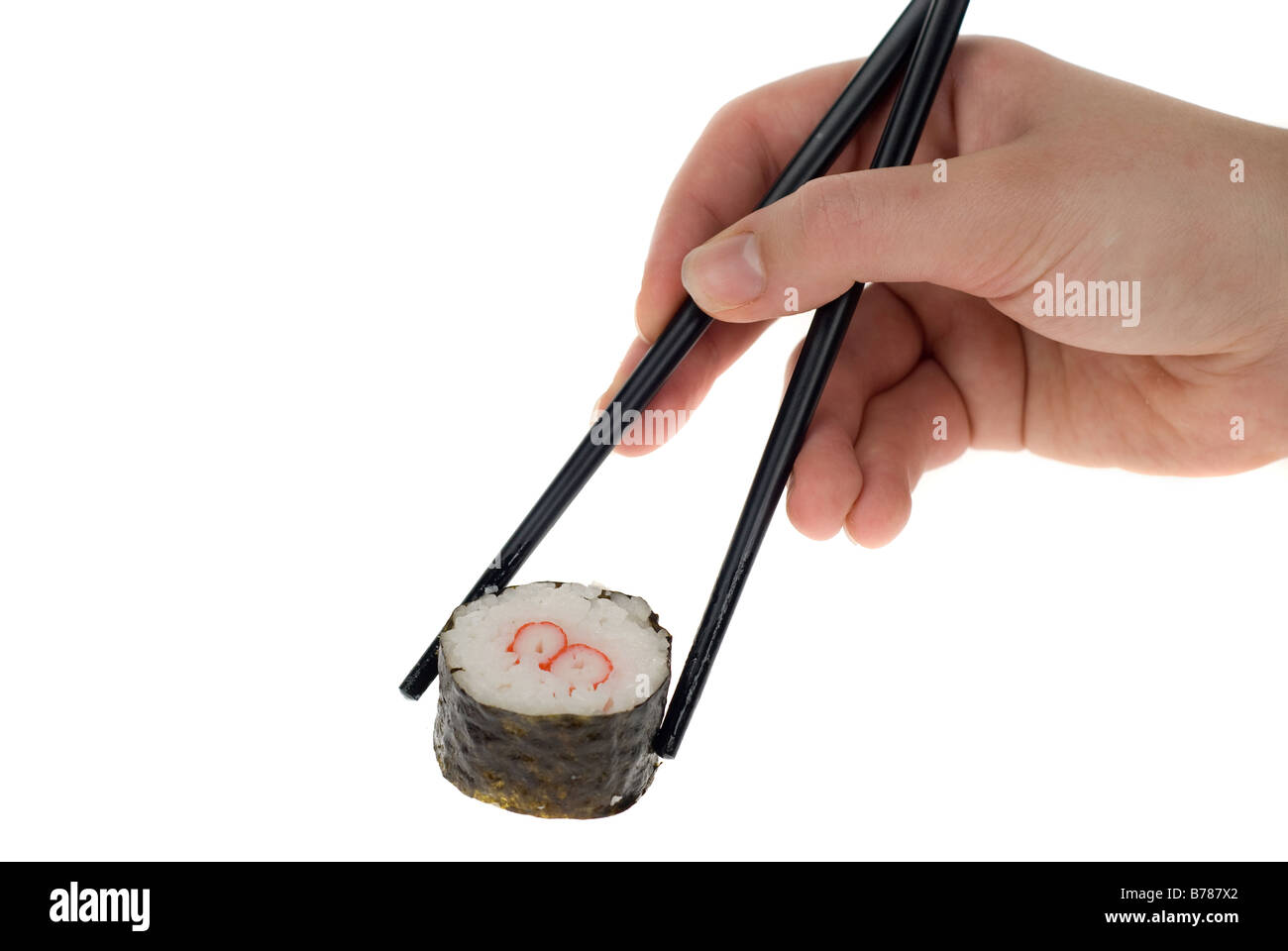 a hand with chopsticks picking up a sushi roll isolated on white Stock Photo