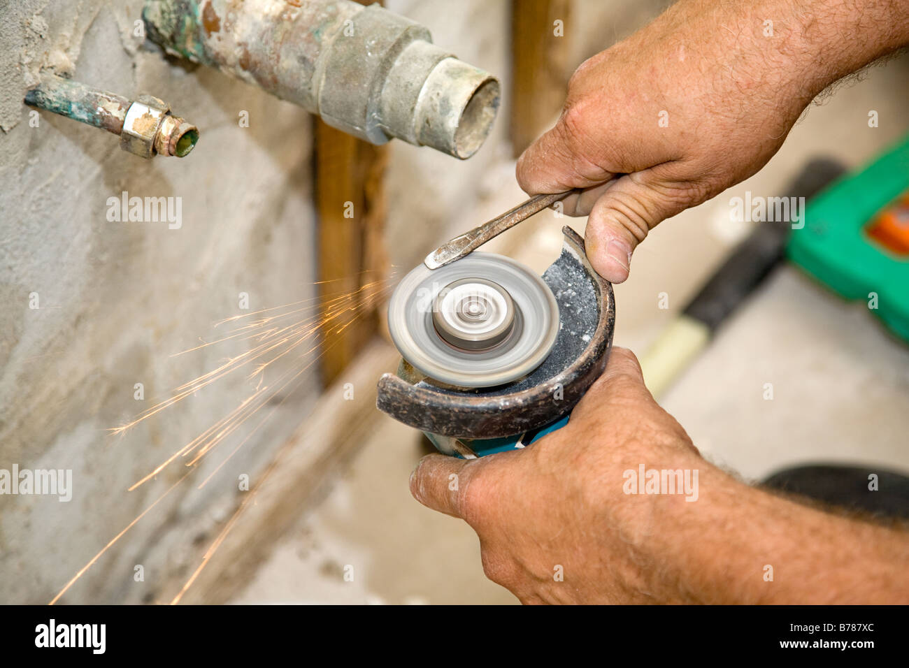 Plumber using a hand held grinder to sharpen a screwdriver Authentic