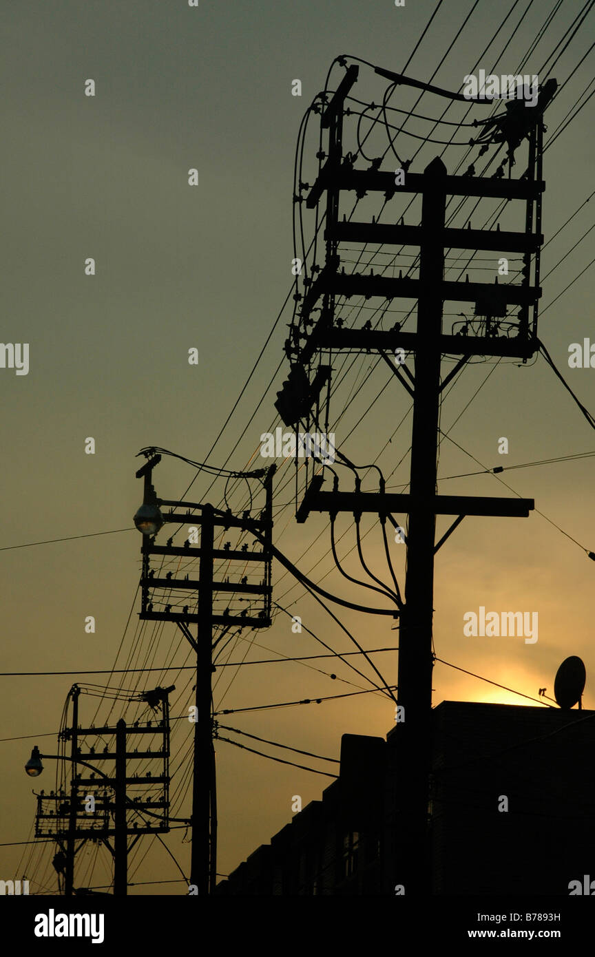 Telephone poles, street lights, sunset. looking west toward the horizon Stock Photo