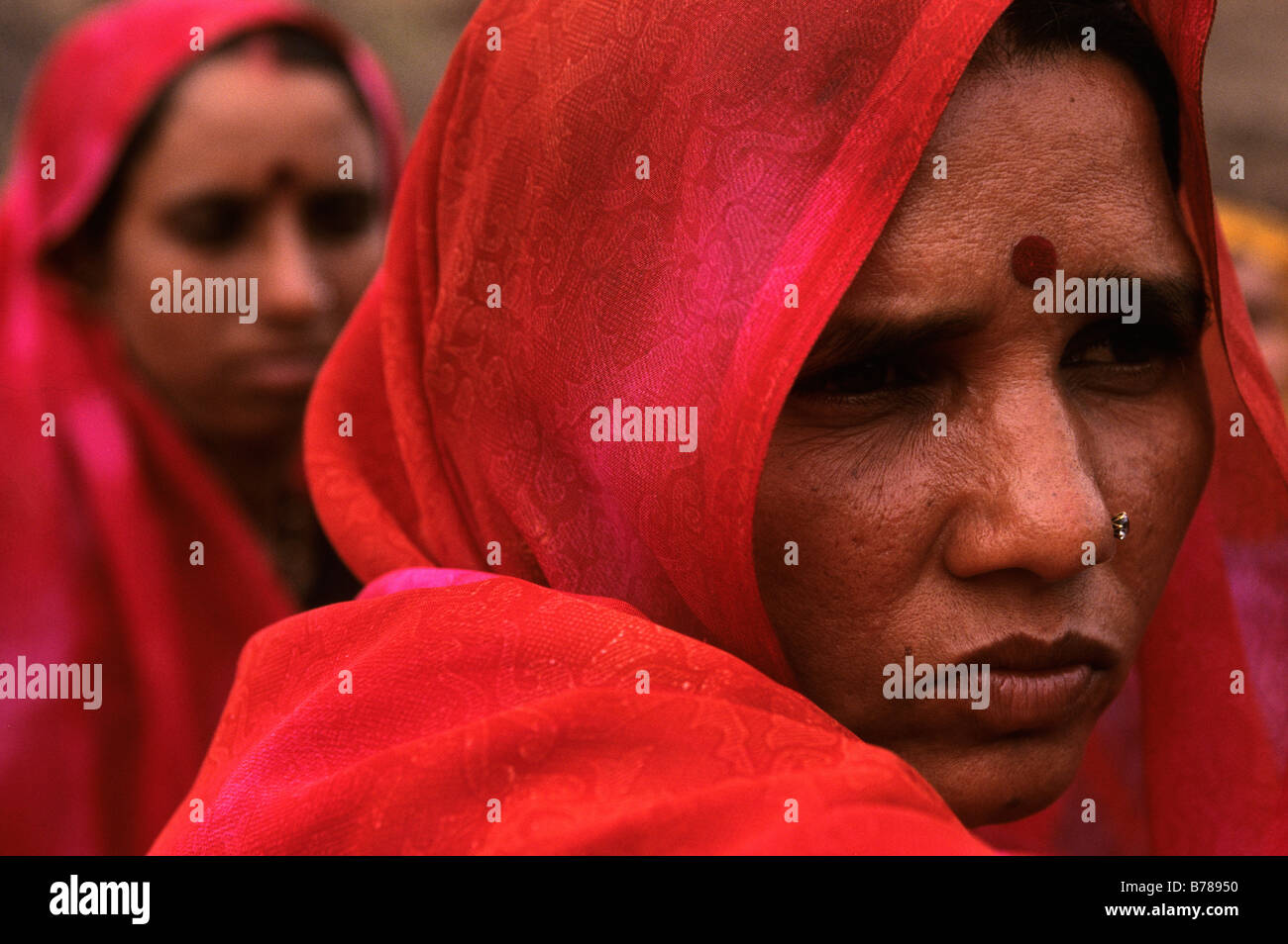 A woman wearing a red sari awaits the destruction of her house by the rising waters of the Narmada Dam' Stock Photo