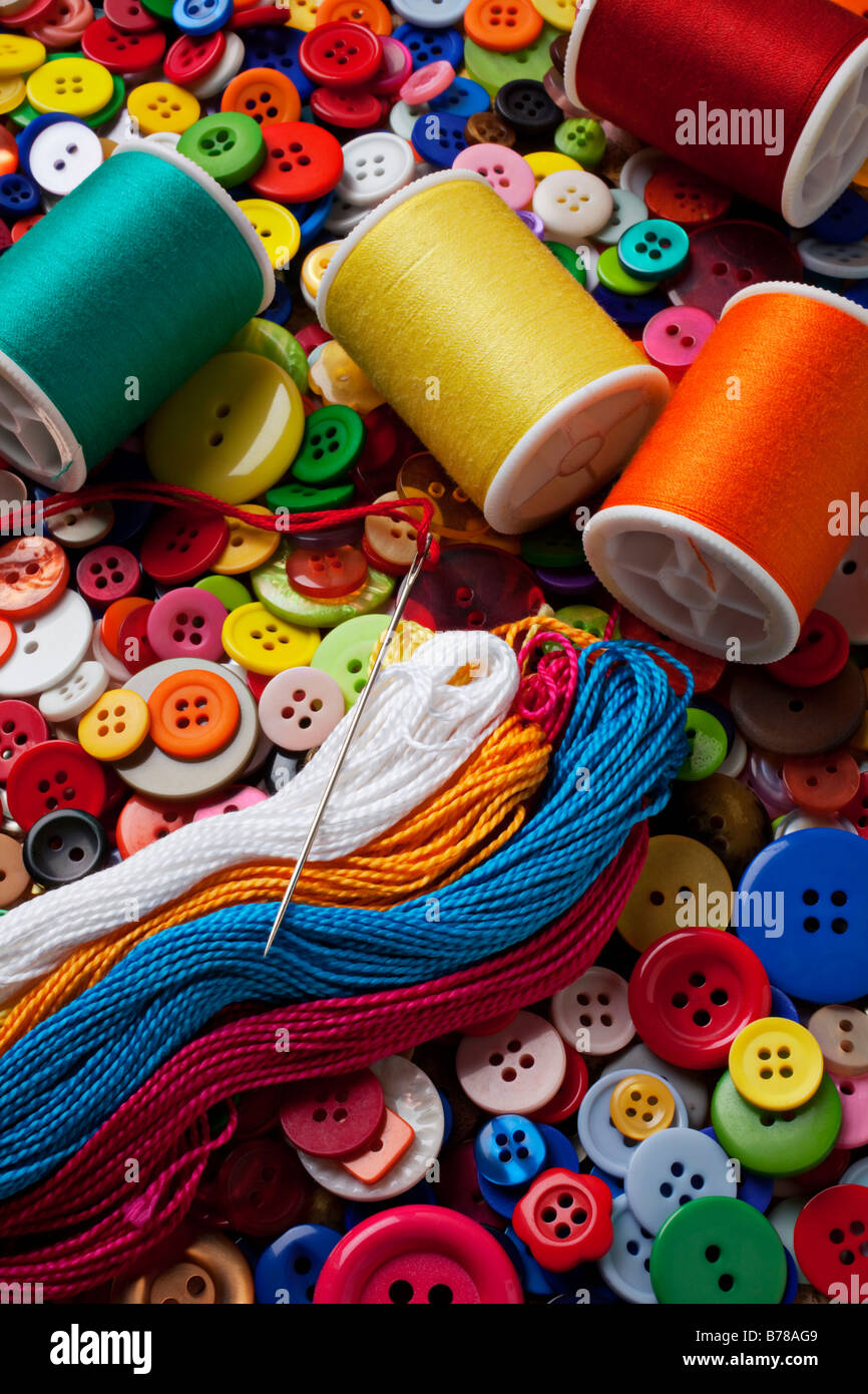 Spools of thread and buttons with needle Stock Photo