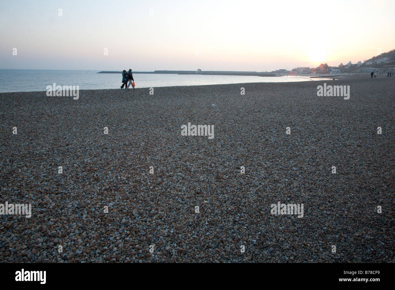 Couple walking along Lyme Regis beach Stock Photo
