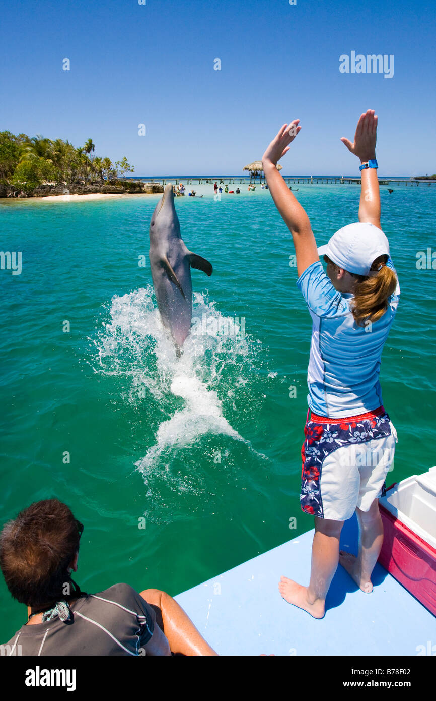 School girl training a dolphin during a biology lesson with a dolphin trainer in Anthony's Key Resort, Roatan, Honduras, Centra Stock Photo