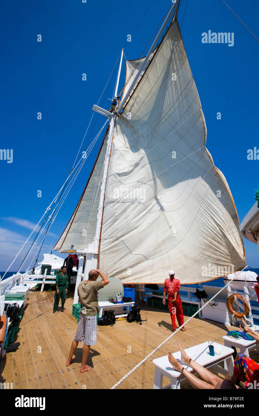 Men setting sail on a sailing ship, Indonesia, Southeast Asia Stock