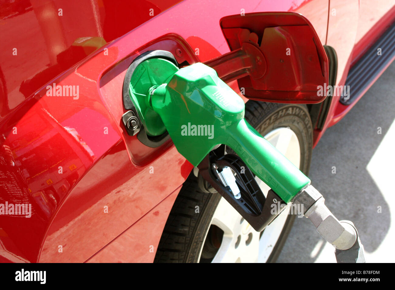 bright green gas pump in red car Stock Photo