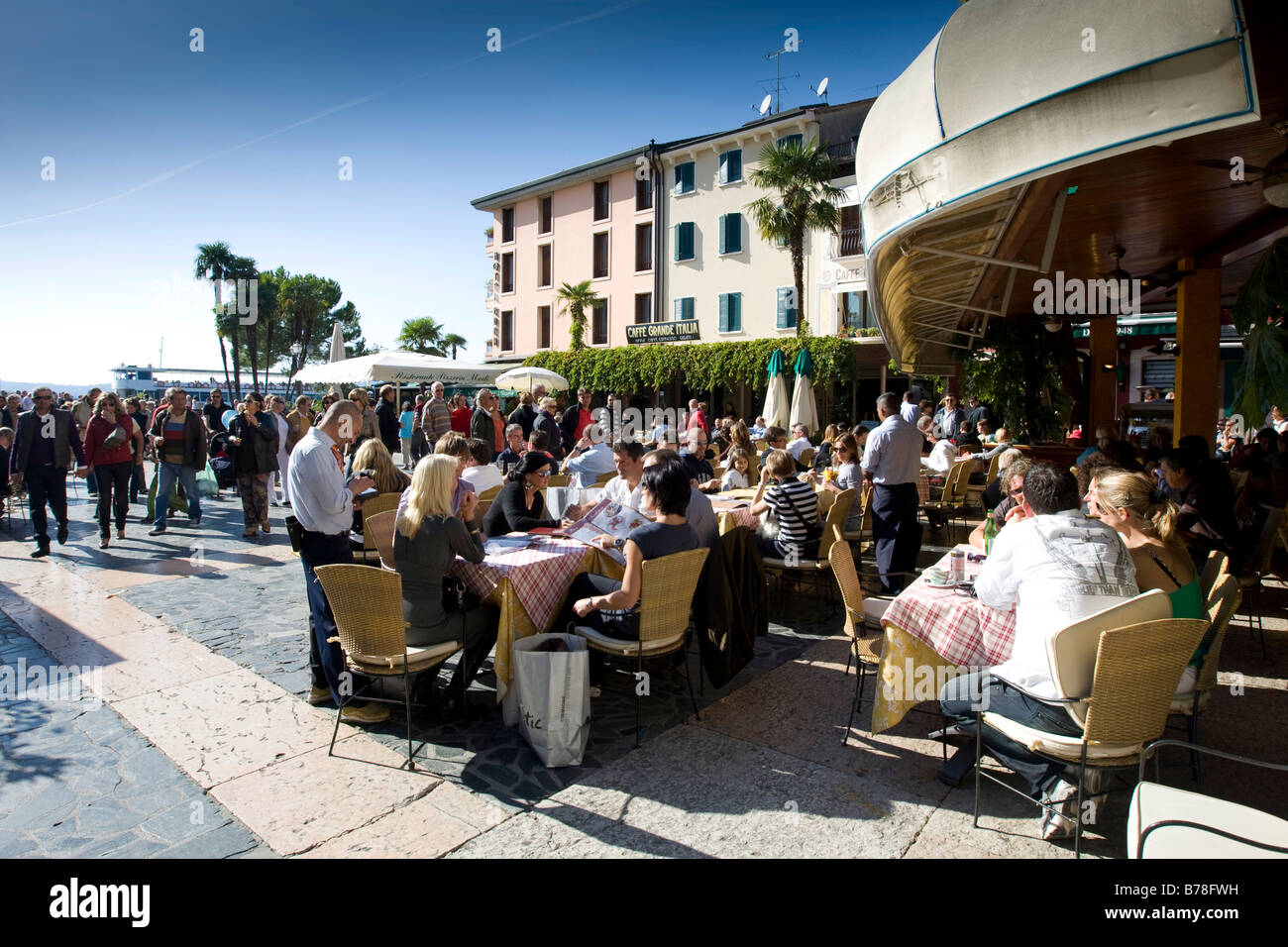 Tourists sitting in a restaurant on the promenade of Sirmione, Lake Garda, Lago di Garda, Lombardy, Italy, Europe Stock Photo