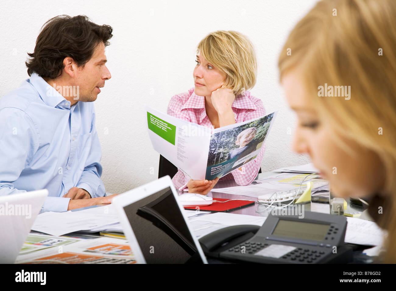 Employees of an advertising agency discussing an ad brochure and blueprints of an ad campaign, Zurich, Switzerland, Europe Stock Photo