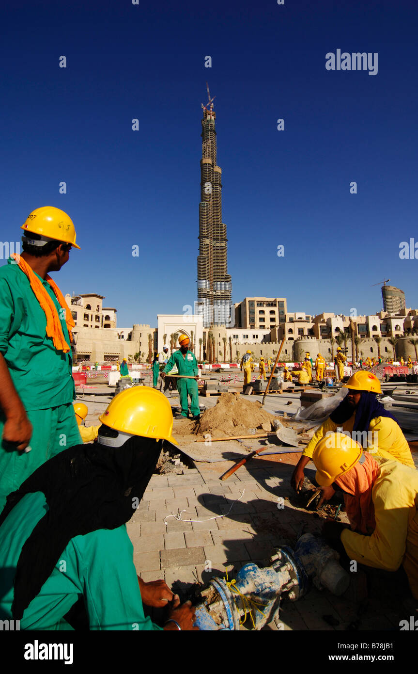 Construction workers in front of the highest skyscaper in the world, Burj Dubai, Dubai, United Arab Emirates, UAE, Middle East Stock Photo