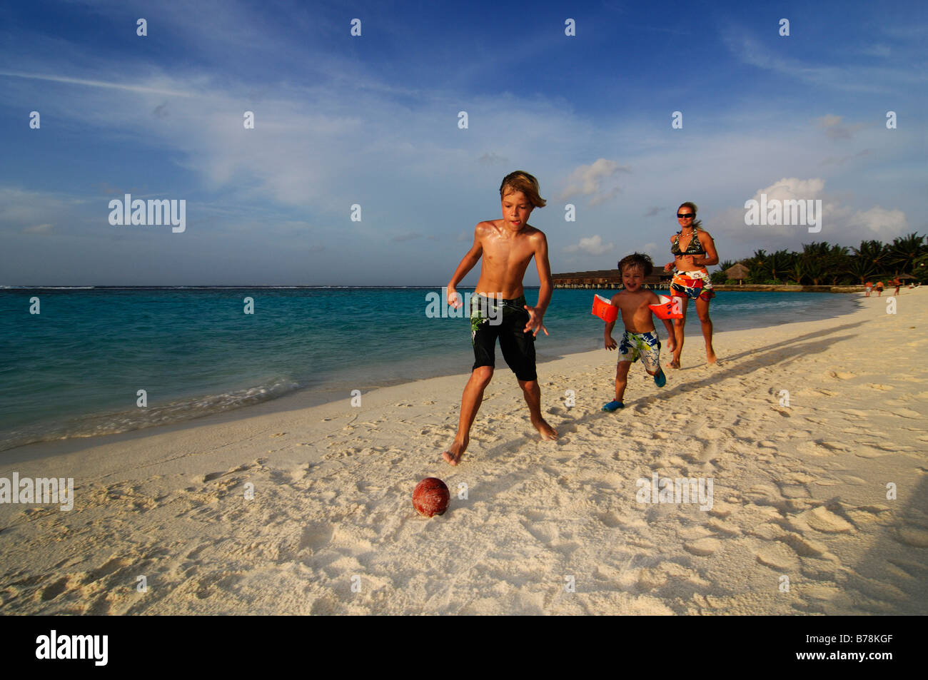 Children playing football on the beach of Laguna Resort, The Maldives, Indian Ocean Stock Photo