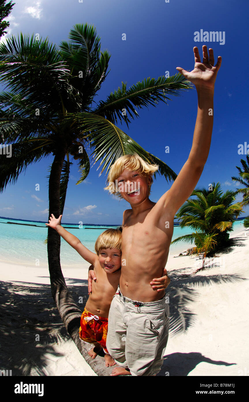 Children on a palm tree trunk in Kurumba Resort, The Maldives, Indian Ocea Stock Photo