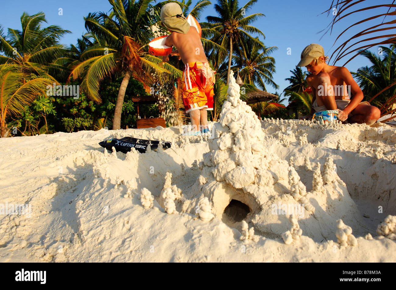 Children building a sand castle on the beach, Kurumba Resort, The Maldives, Indian Ocean Stock Photo