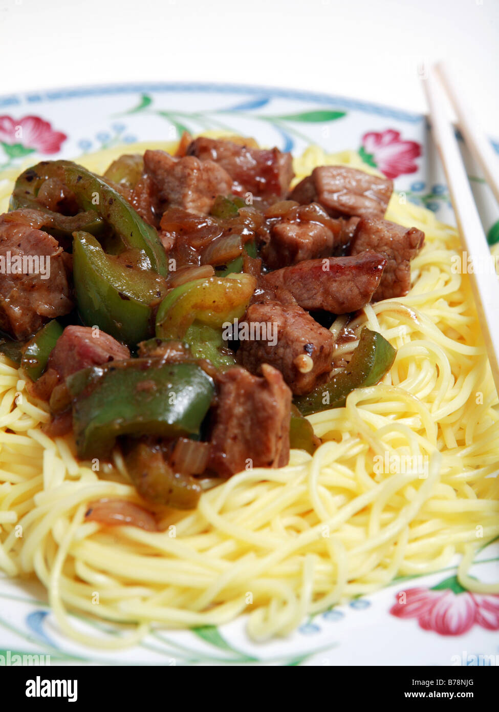 A view of beef and capsicums cooked in a black bean,ginger and garlic sauce,served on thin egg noodles. Stock Photo