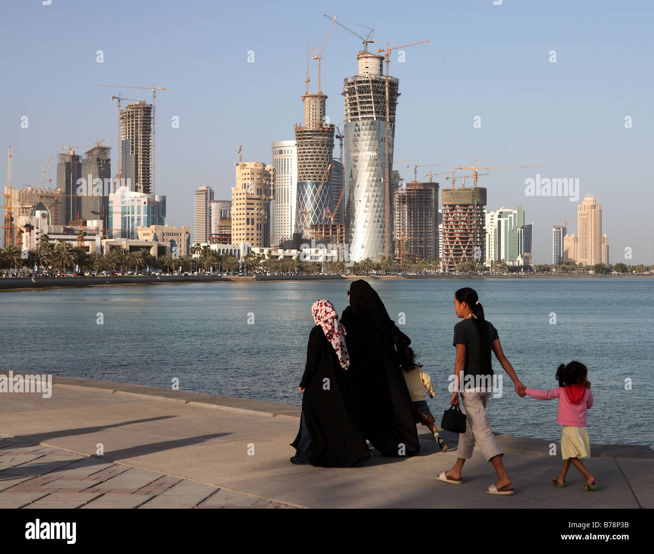 Covered Qatari women with their children and housemaid strolling on the Corniche in Doha,Spring 2008. Stock Photo