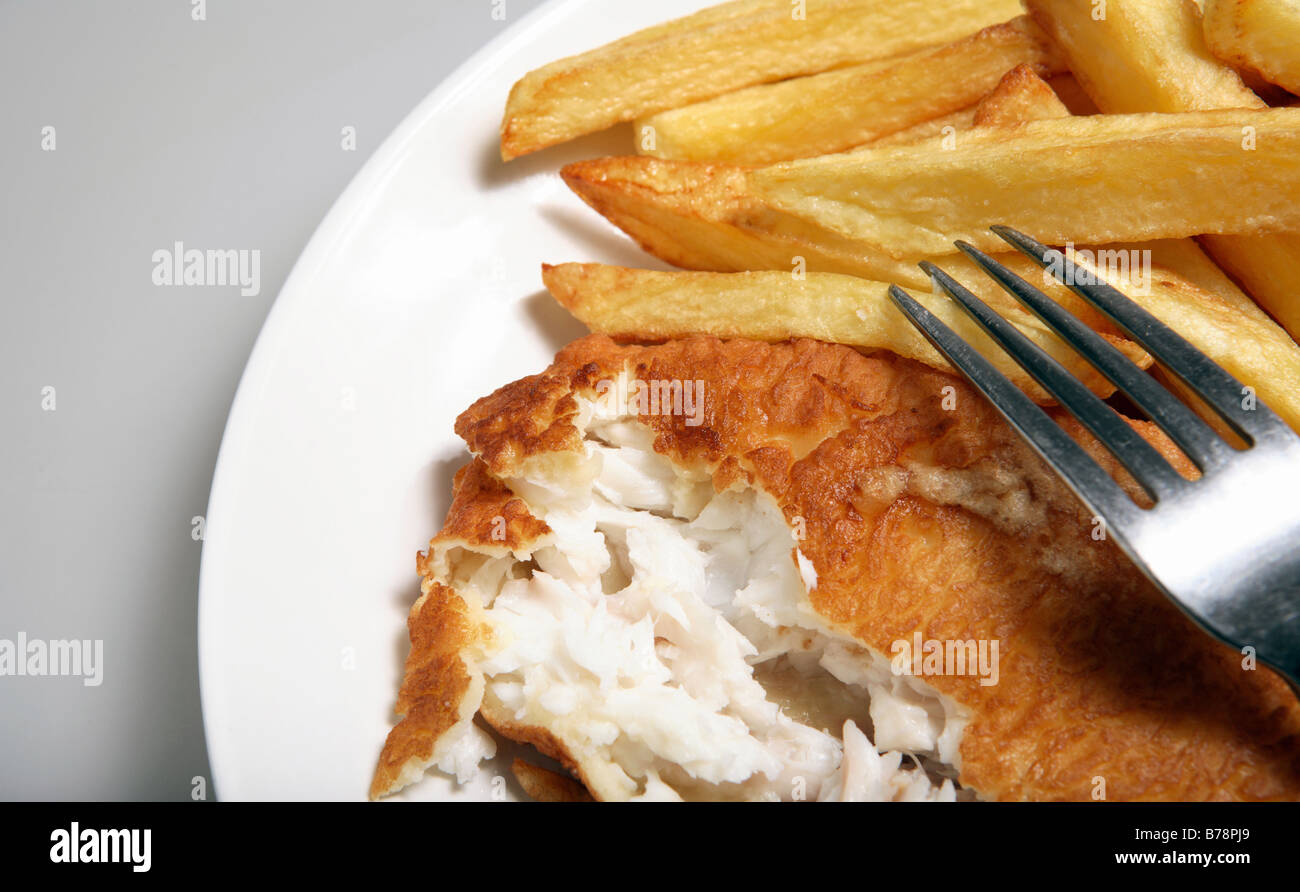 A plate of English-style fish and chips,with thick cut 'french fries' and battered fish. Stock Photo