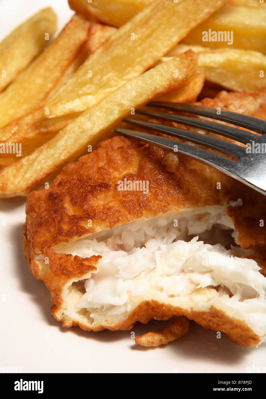 Traditional British home-made fried fish in batter with thick-cut chips. Stock Photo