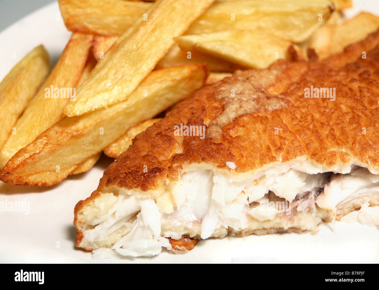 Traditional British home-made fried fish in batter with thick-cut chips. Stock Photo