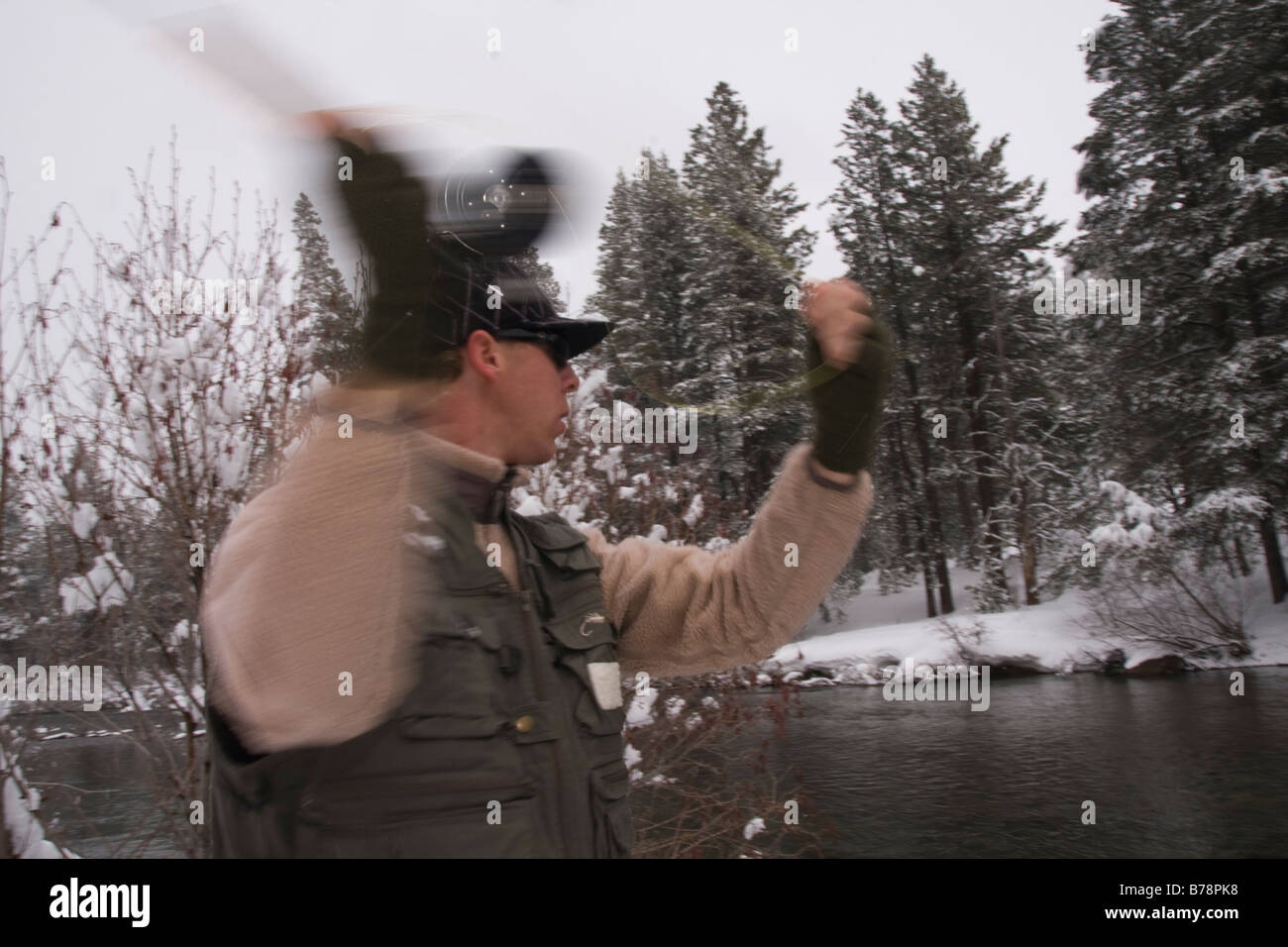 A man fly fishing on a snowy day on the Truckee river near Truckee in California Stock Photo