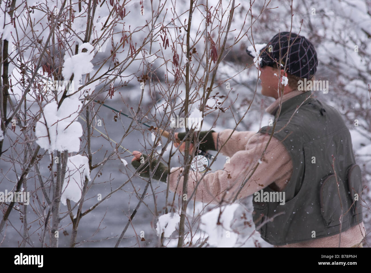 A man fly fishing on a snowy day on the Truckee river near Truckee in California Stock Photo